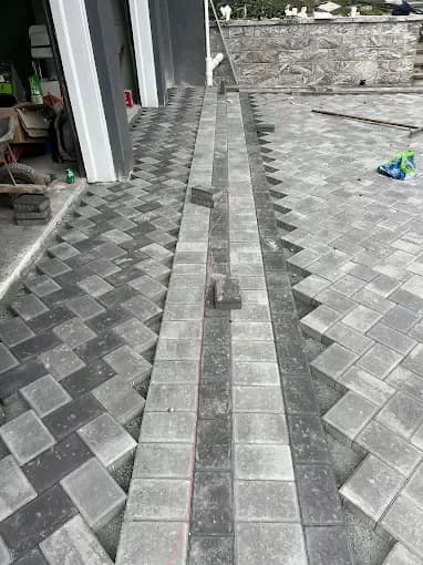 Herringbone paver pattern with contrasting border being installed