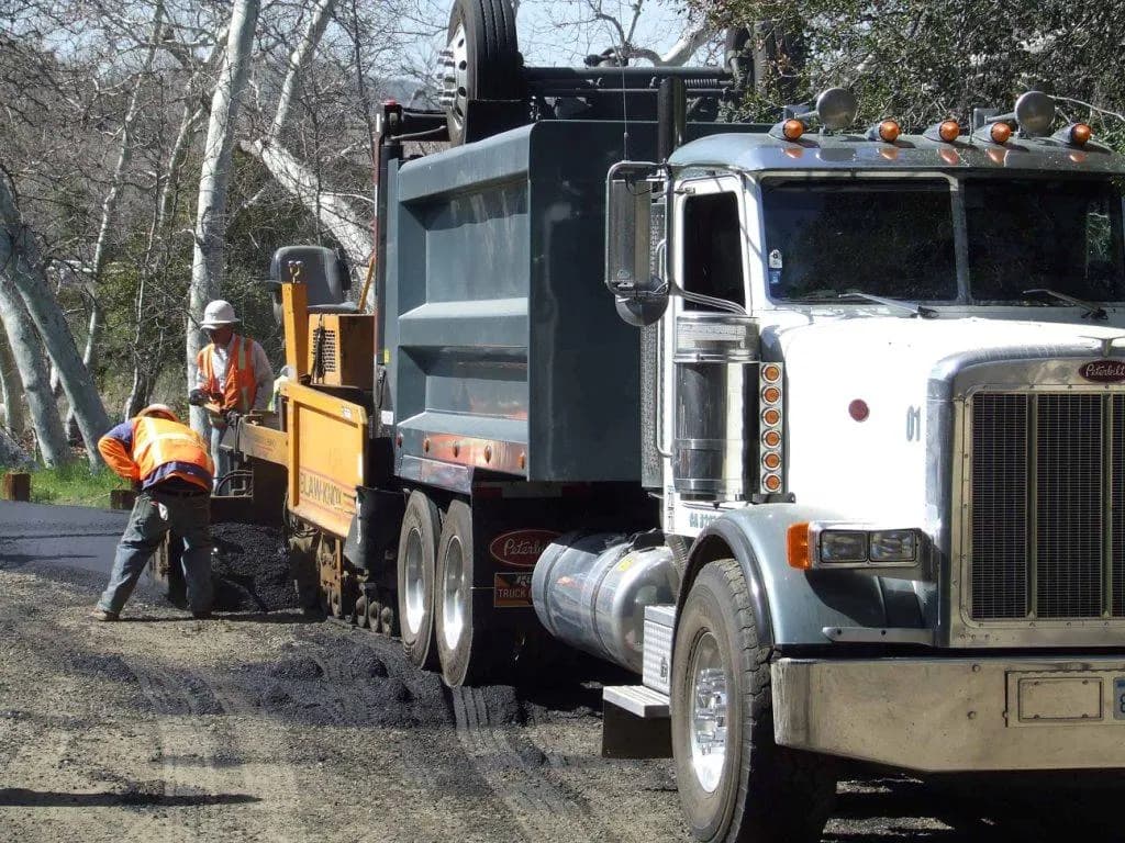 Asphalt paving machine laying hot mix on a road