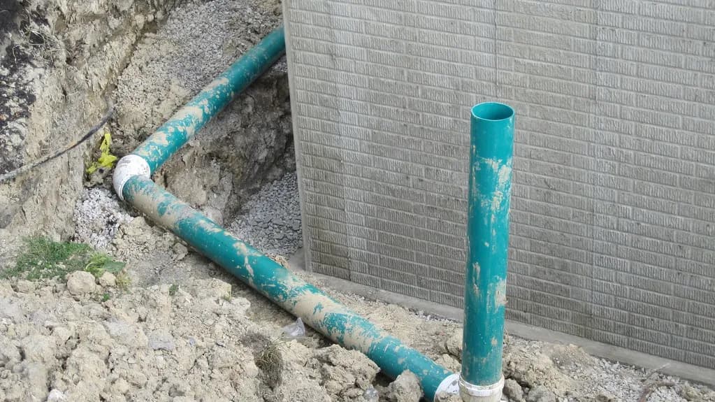 Drain tile pipe beside a foundation footing